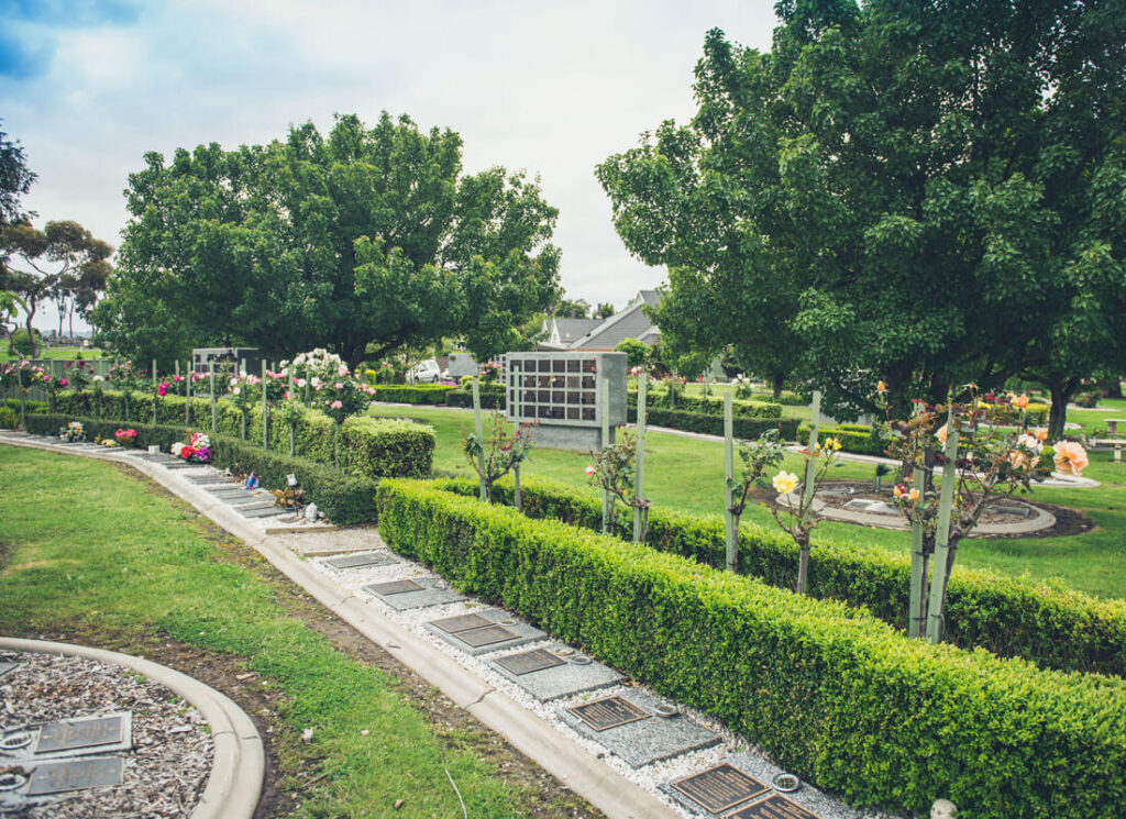 Gardens with roses and nicehe walls at cemetery