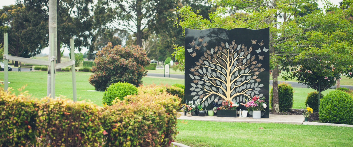 Trimmed hedges, mowed lawns and Memorial Tree wall