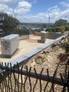 Two niche walls overlooking water in distance.