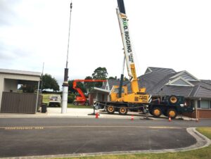 Crane placing large cylinder on ground