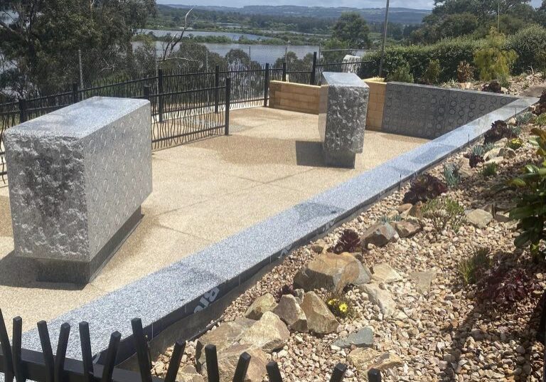 Two niche walls overlooking water in distance.