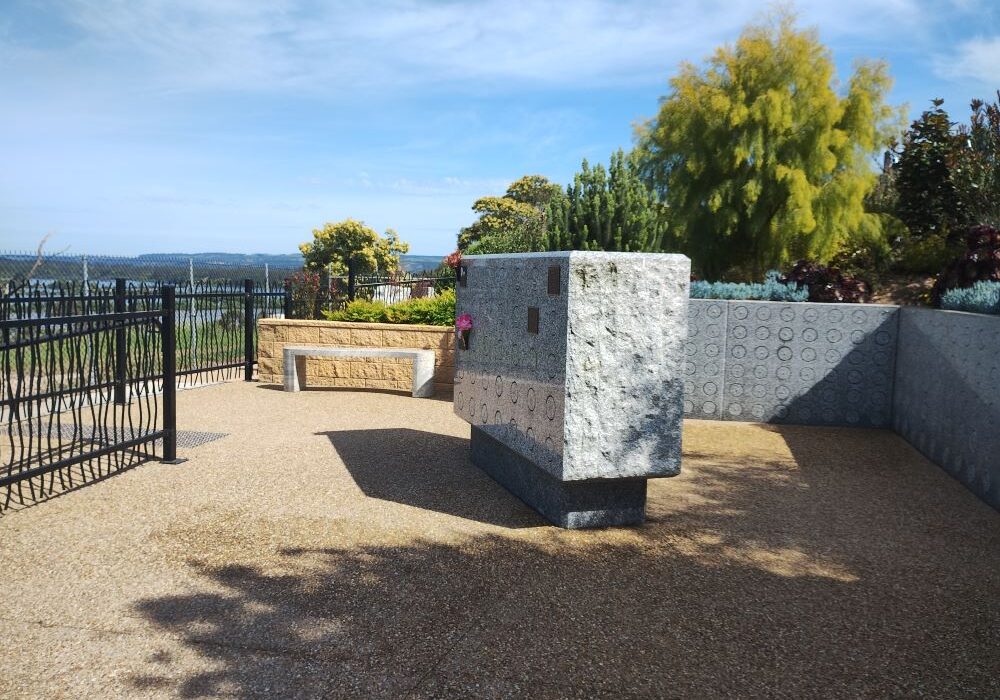 Granite seat in front of stone wall with niche wall in foreground