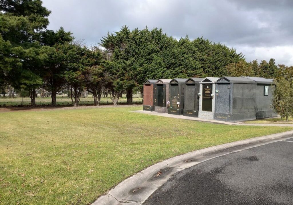 Green lawn beside a line of crypts